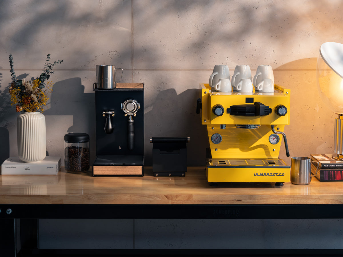 Barista Bar EIche und gelbe Espressomaschine mit drei Tassen auf einer Holzarbeitsplatte, dekoriert mit Blumen und Büchern @expand #material_Eiche