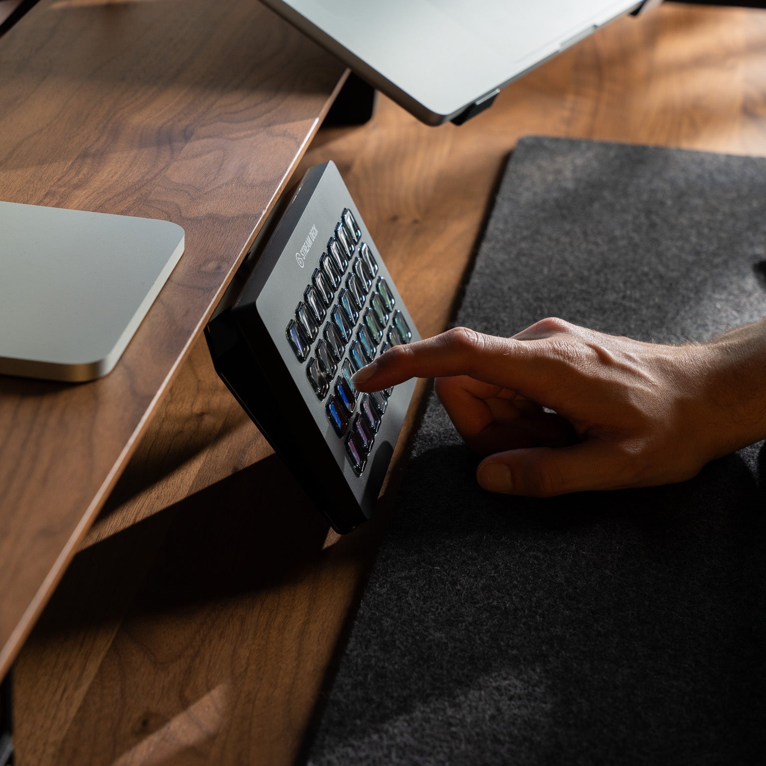 BALOLO Stream Deck XL Halter montiert an BALOLO Setup Cockpit aus massivem Nussbaum Holz in modernem Office Setup. Veranschaulicht mit Elgato Stream Deck XL und Hand die Knöpfe bedient.