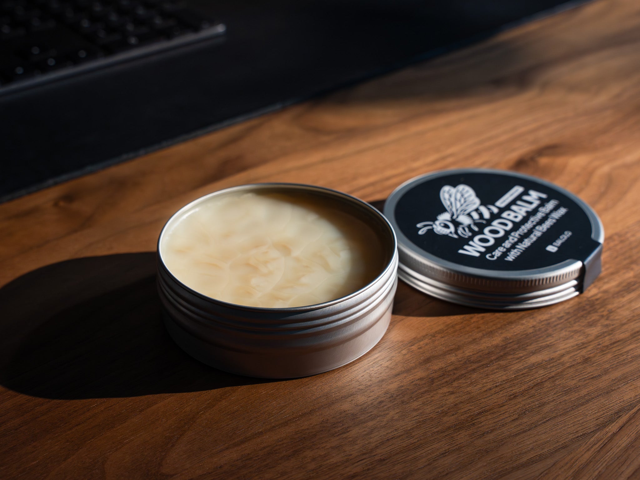 Detailaufnahme BALOLO Holzpflege mit Bienenwachs, inszeniert auf Nussbaum Schreibtisch. @expand