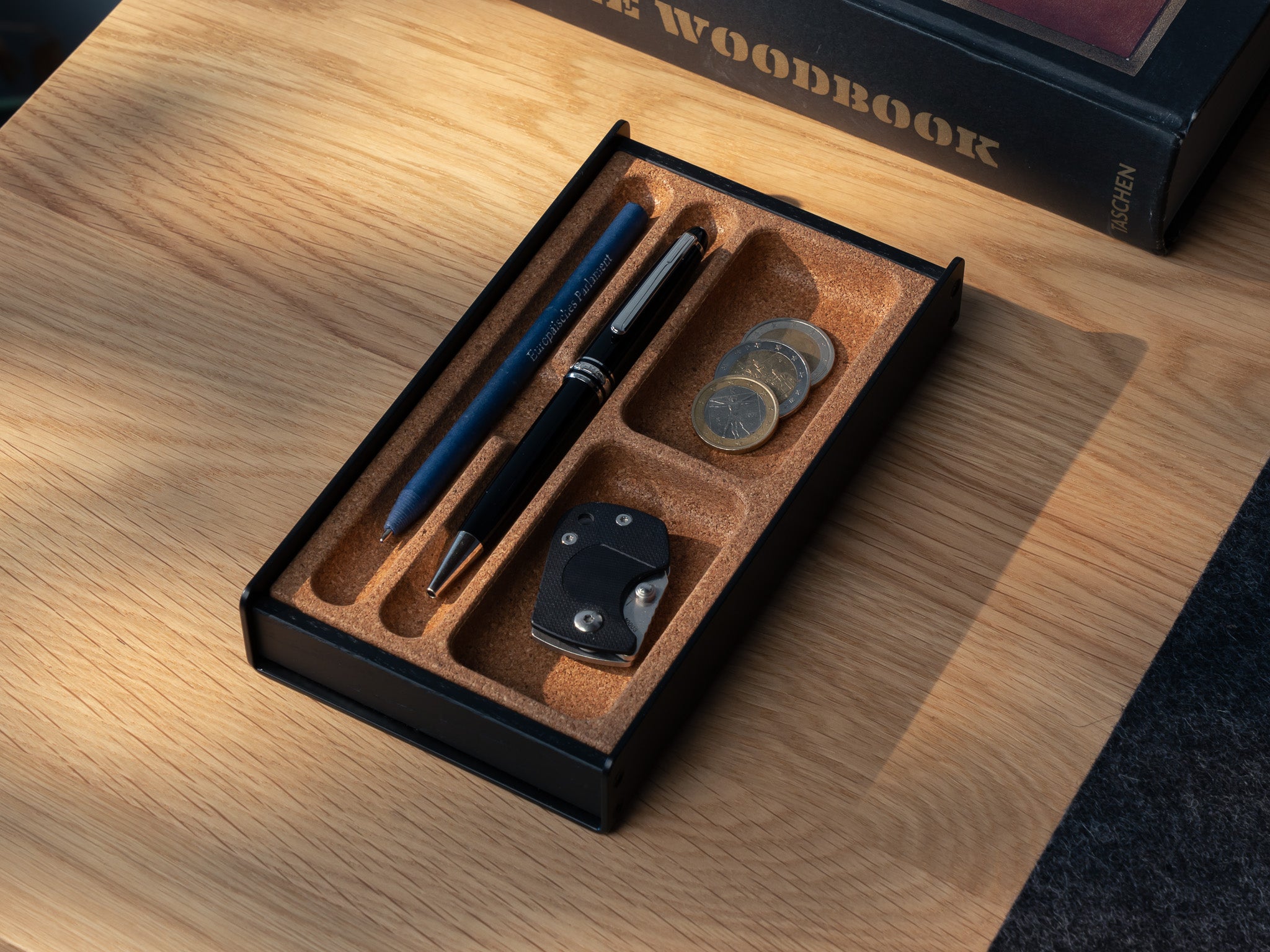 Totalaufnahme des Organizers für die Stiftablage in All Black. Veranschaulicht mit SD Karten, Stift und Münzen. @expand #material_All Black