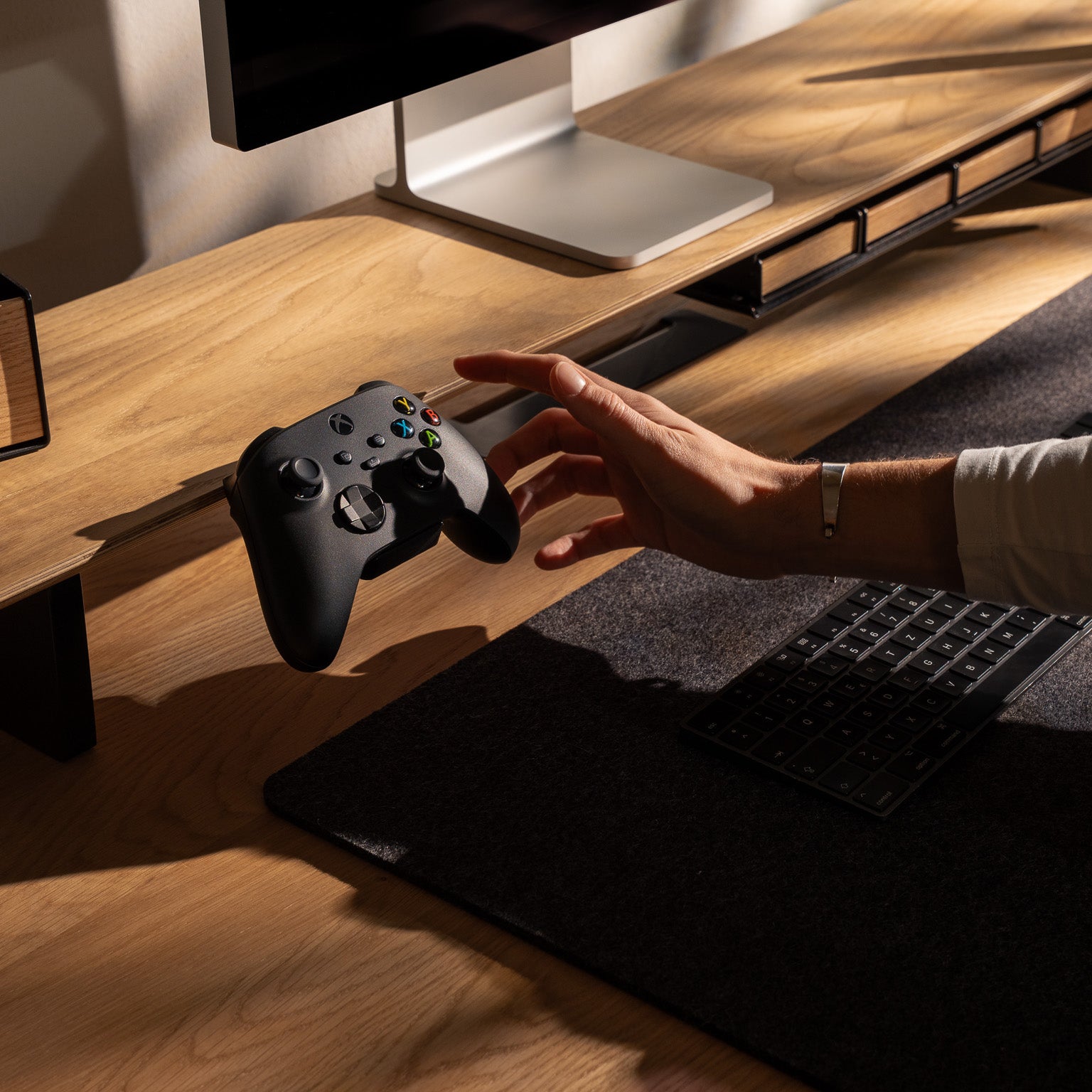 Detailaufnahme vom BALOLO Controller Halter mit Xbox Controller montiert am Setup Cockpit in Eiche in ästhetischen Schreibtischsetup. 