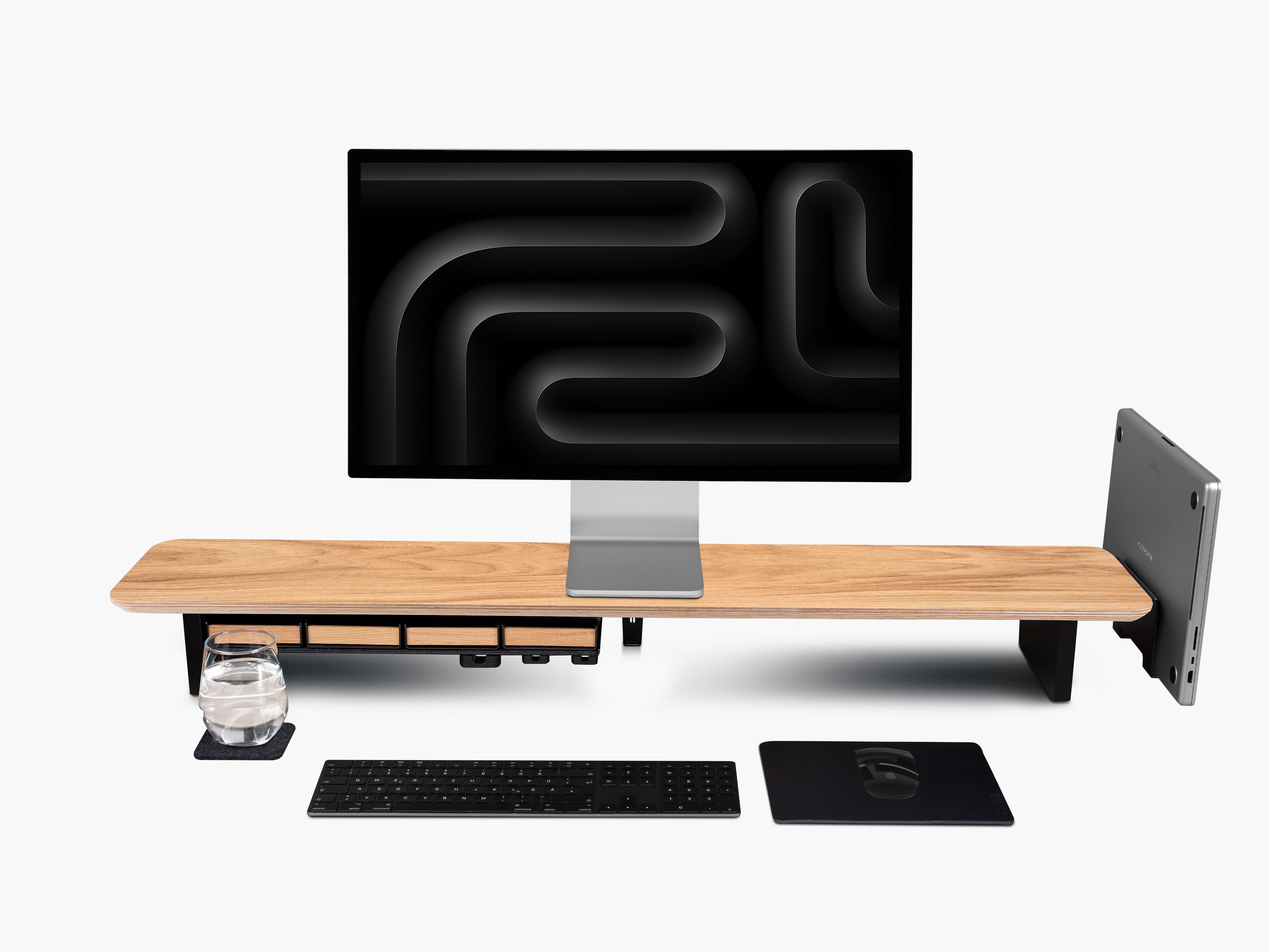 Setup Cockpit Large Monitorständer aus Eiche mit Anbauteilen: Laptop Dock, Großes Fach mit vier Stiftablagen, Kabelmagnete, Mauspad Leder und Desk Coaster. Abgebildet mit Apple Studio Display, Tastatur und Maus. 